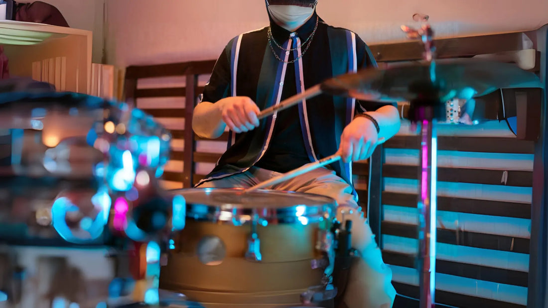 Masked drummer playing indoor kit with lights